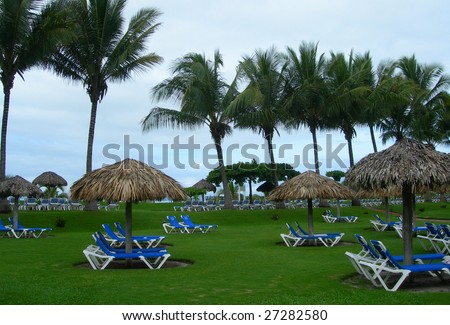 Resort in Costa Rica with lounge chairs, palm trees and huts