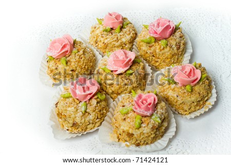 Seven cakes with nuts, decorated with rosettes. Isolated on white background.