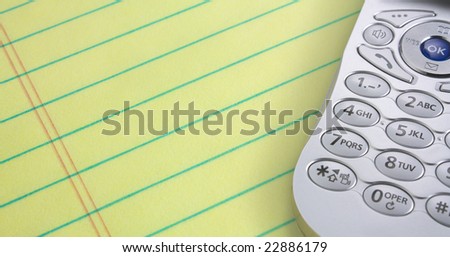 Cell phone on a yellow legal pad of paper