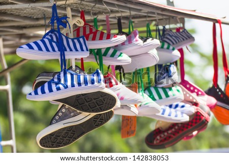 Lot of sneakers   shoes multicolored hanging on roof