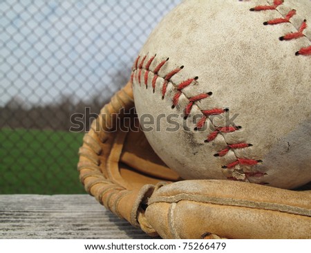 Beautiful old softball with shallow depth of field in a vintage mitt on the sidelines