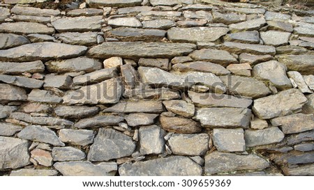 An old natural stone wall with large and small stones/Natural stone wall