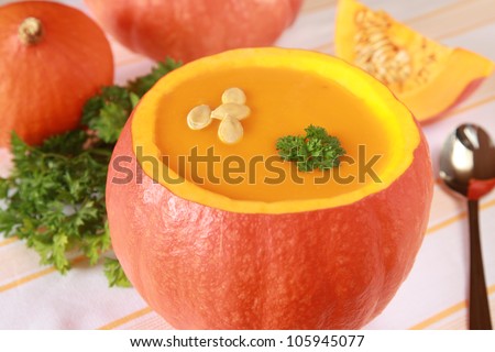 Pumpkin soup in a pumpkin and more pumpkins in the background