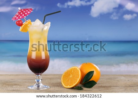 Tequila Sunrise cocktail with oranges on the beach while on vacation