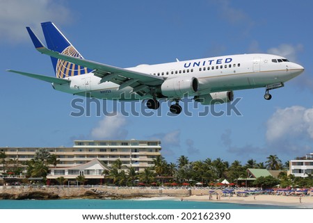 ST. MARTIN - FEBRUARY 8: A United Airlines Boeing 737 approaching on February 8, 2014 in St. Martin. St. Martin is rated one of the most dangerous airports in the world.