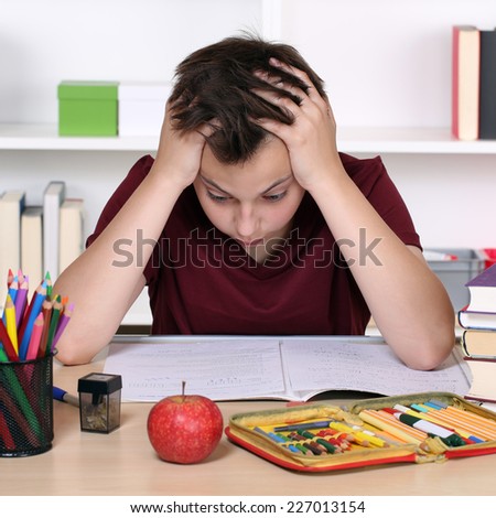 Young student has stress and is desperate at school while doing homework