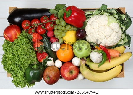 Fruits and vegetables like oranges, apple, tomatoes, banana in wooden box groceries from above