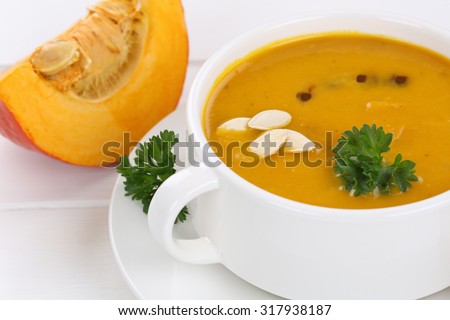 Pumpkin soup closeup with fresh pumpkins in cup
