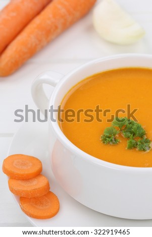 Carrot soup meal with fresh carrots in bowl closeup