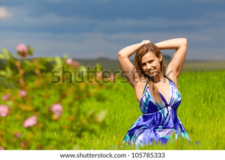 girl sitting on the grass in a light blue dress from the fabric