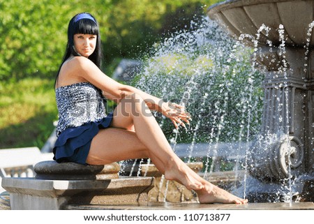Girl on Fountain. Girl sitting in front of a water fountain.