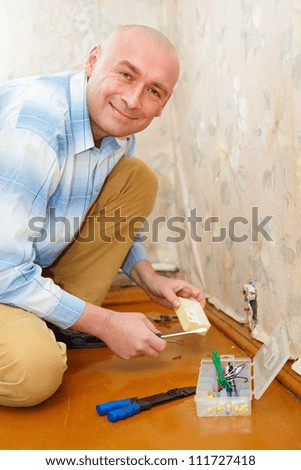 Electrician Installing Wall Socket in the house