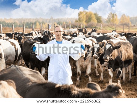 Portrait of  Vet Doctor with blank advertising board or copy space  at  farm cow