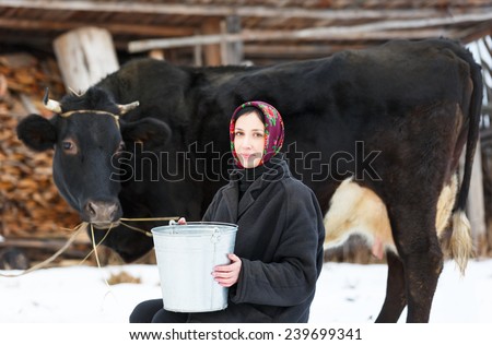 woman with a bucket for milking cows in  winter