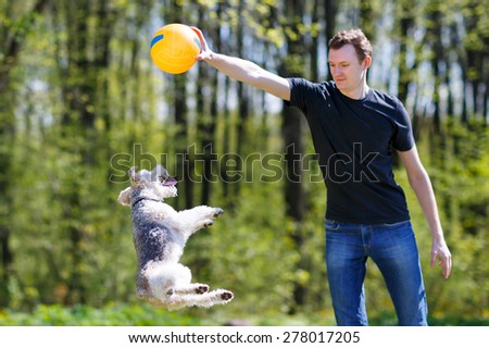 Young man playing with his dog in the park