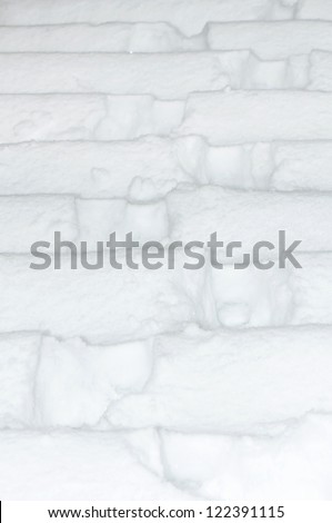 Stairs under heavy snow with footprints