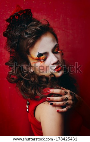 Queen of Spades. Young woman with art makeup and hair-do. Long false lashes and little crown made of hairs.