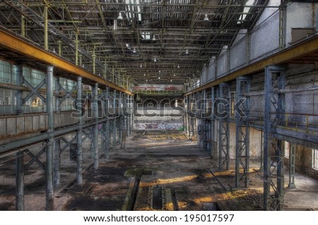 Light rays in a large abandoned production hall with an old crane