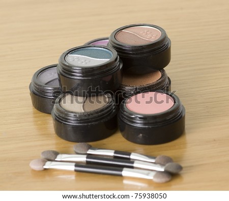 colorful set of eye shadow makeup isolated on a wooden background