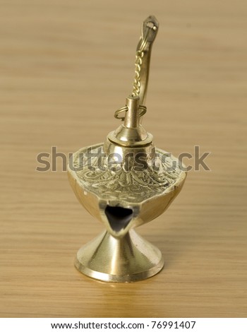 golden genie lamp isolated on a wooden background