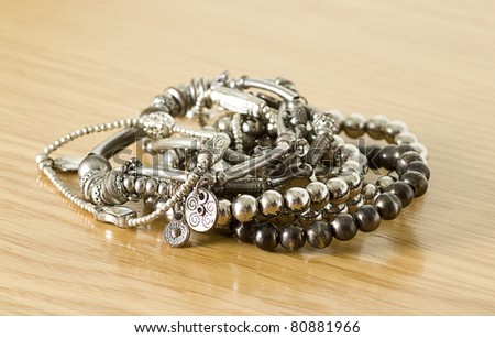 pretty silver bracelets isolated on a wooden background