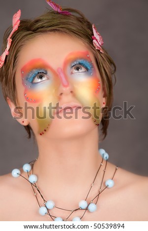 girl with butterfly make-up on face look up