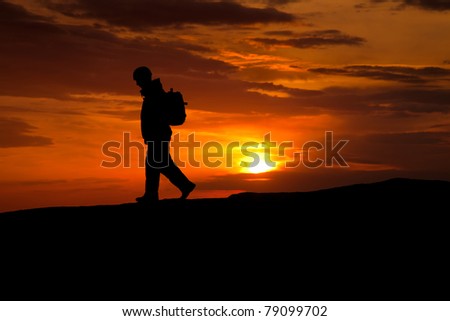 silhouette of rock climber on sunset sky