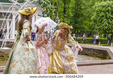 ST PETERSBURG, RUSSIA - JUNE 13, 2014: Petrodvorets, people are photographed in a vintage clothes.  Petrodvorets is a popular tourists destination.