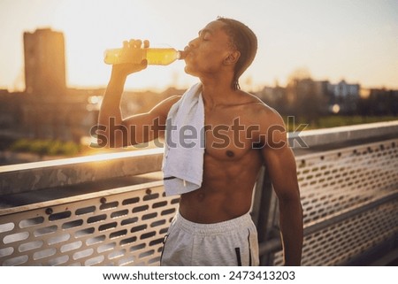 Similar – Foto Bild Junger Stadtsportler trinkt Wasser in einer Gymnastikhalle im Freien