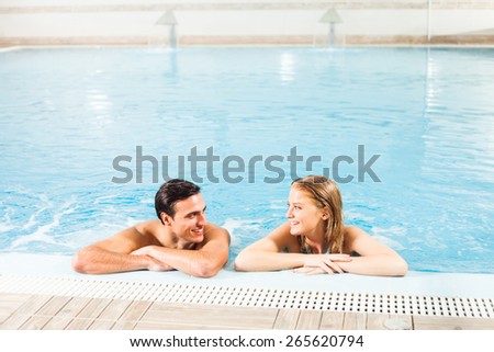 Young couple at the swimming pool enjoying hydro massage