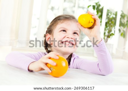Happy child holding orange and lemon