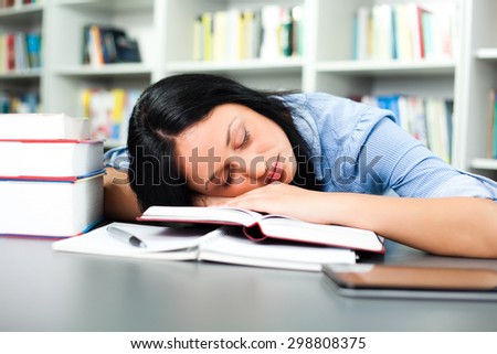 Tired student sleeping in library