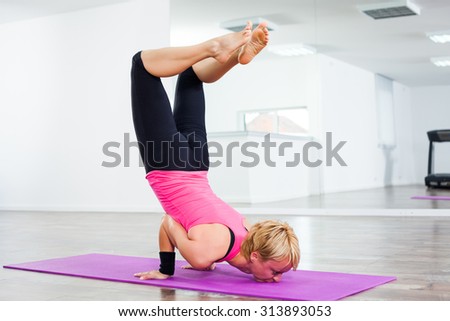 Girl practicing yoga, Vrschikasana/Scorpion pose