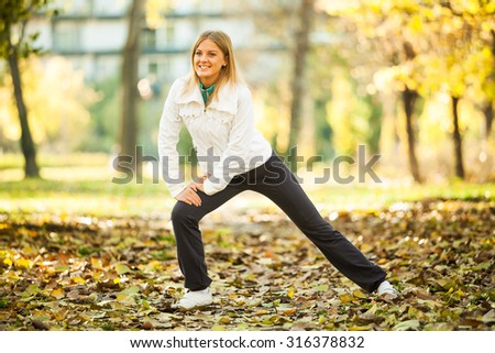 Young happy woman exercising in park