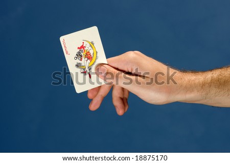 Hand holding joker card,blue sky in background