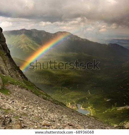 View of the green mountains, valley, lake, mountain hut, and a rainbow. Slovakian Tatra Mountains.