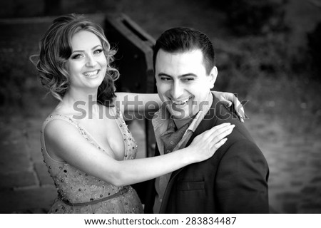 Newly wed couple laughing outdoor on a summer day.