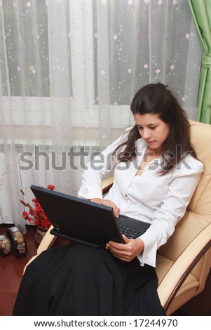 Young woman working at the laptop in the comfort of her home.