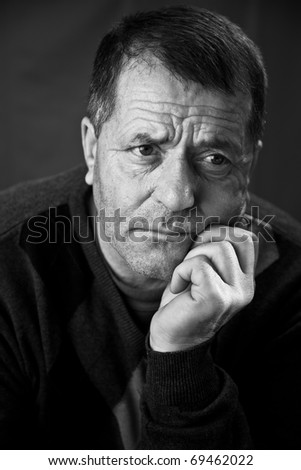 Black and white portrait of a middle aged man with a serious look on his face.