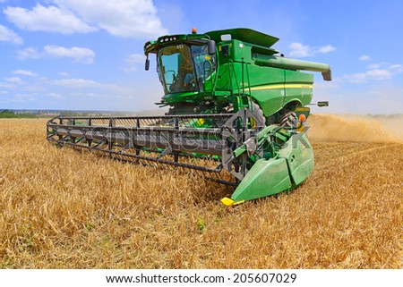 Kalush, Ukraine - AUGUST 7: Modern John Deere combine harvesting grain in the field near the town Kalush, Western Ukraine August 7, 2013