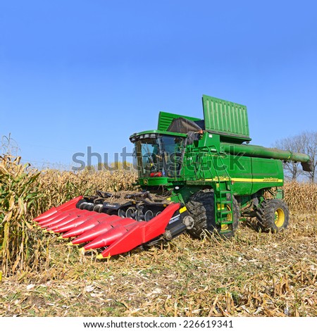 Kalush, Ukraine - OCTOBER 14: Modern John Deere combine harvesting corn  in the field near the town Kalush, Western Ukraine October 14, 2014