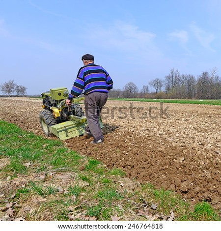 Kalush, Ukraine -April 28: A farmer processes a spring field the motor-block near the town Kalush, Western Ukraine April 28, 2013
