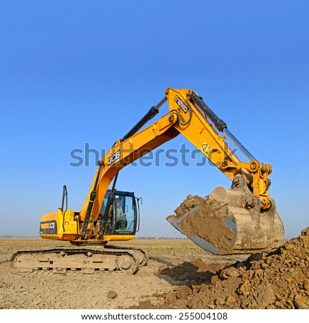 Kalush, Ukraine  October 14: Modern JCB excavator on the highway pipeline performs excavation work in the field near the town Kalush, Western Ukraine October 14, 2014