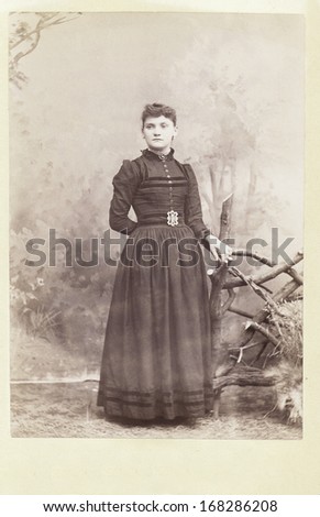 USA - WISCONSIN - CIRCA 1890 - A vintage Cabinet Card  photo of a young woman standing. The woman is dressed in a Victorian style dress. A photo from the Victorian era. CIRCA 1890