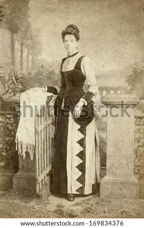 USA - OHIO - CIRCA 1885 - A vintage photo of a young woman. The woman is standing and dressed in a beautiful Victorian style dress. A photo from the Victorian era. CIRCA 1885