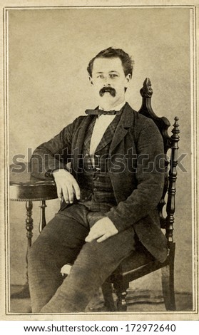 USA - MASSACHUSETTS - CIRCA 1864 - A vintage Cartes de visite photo of a gentleman. The man is sitting with one arm on the arm of the chair. A photo from the Civil War Victorian era. CIRCA 1864