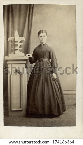 CANADA - PRINCE EDWARD ISLAND - CIRCA 1860 - A vintage Cartes de visite photo of a young woman standing. She is dressed in Victorian style hoop skirt dress.  Photo from the Victorian era.