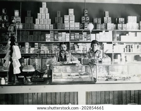 USA - KANSAS - CIRCA 1890 An old vintage photo of an early grocery store stocked with goods. The male store owner and employee are behind the counter. This photo is from the Victorian era. CIRCA 1890