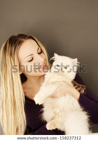 Beautiful young woman holding white Persian kitten
