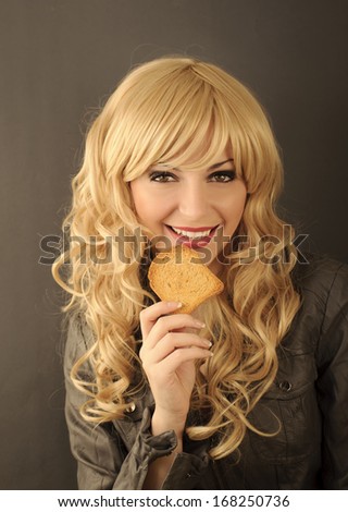 Pretty young woman eating a piece of toast